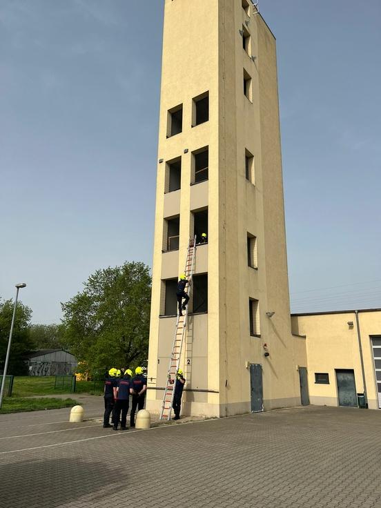 Feuerwehrmänner üben am Schlauchturm mit Leitern